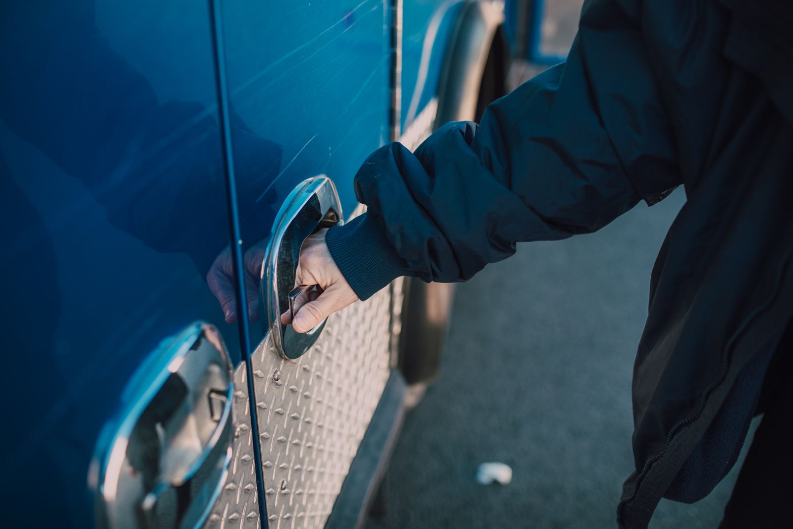 A hand pulling the handle of a locked car door in Hot Springs, AR